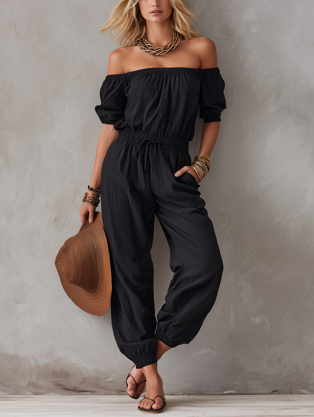 Czarny jumpsuit damski z odkrytymi ramionami, widok z przodu
